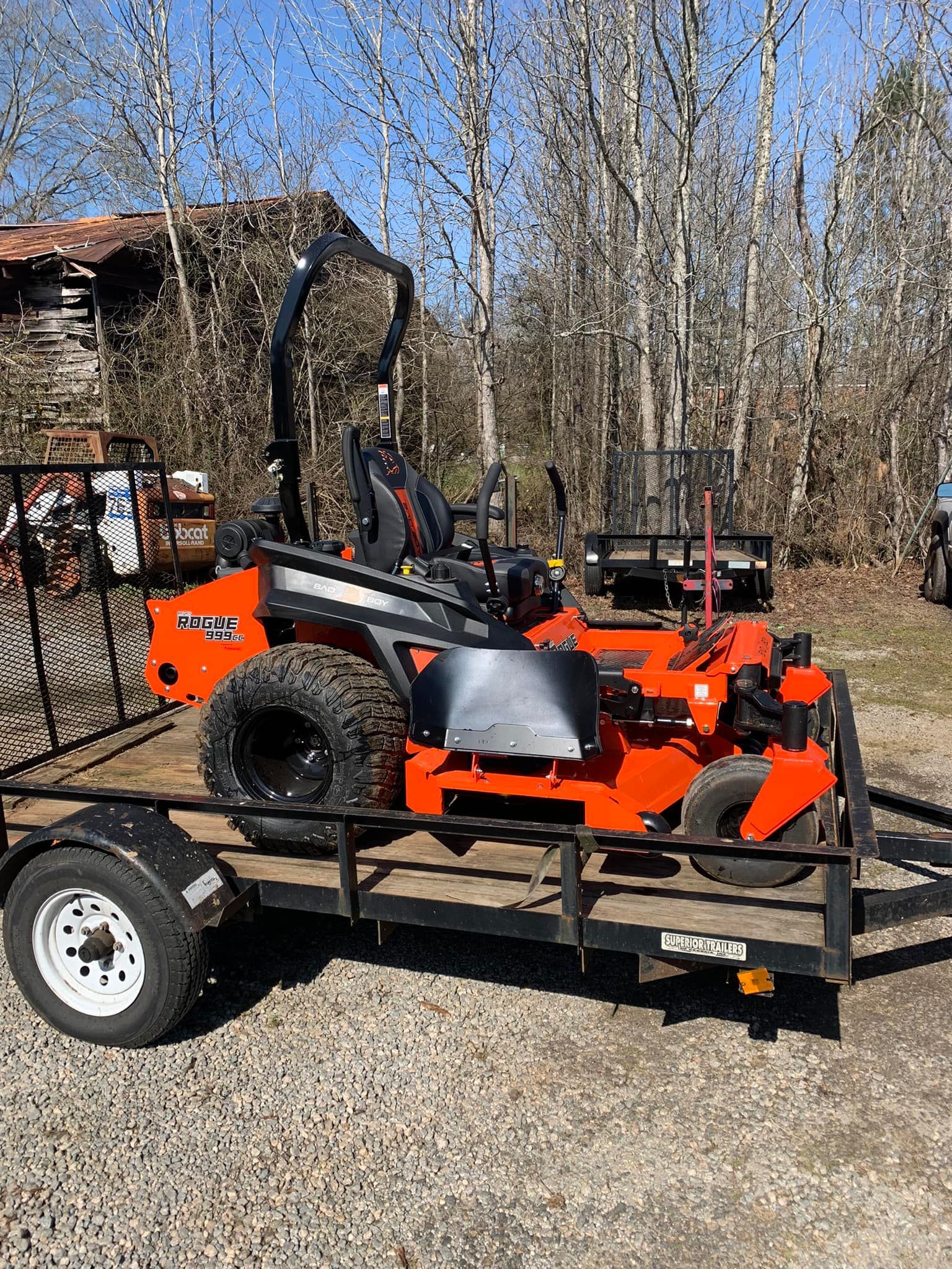 A lawn mower is sitting on top of a trailer.
