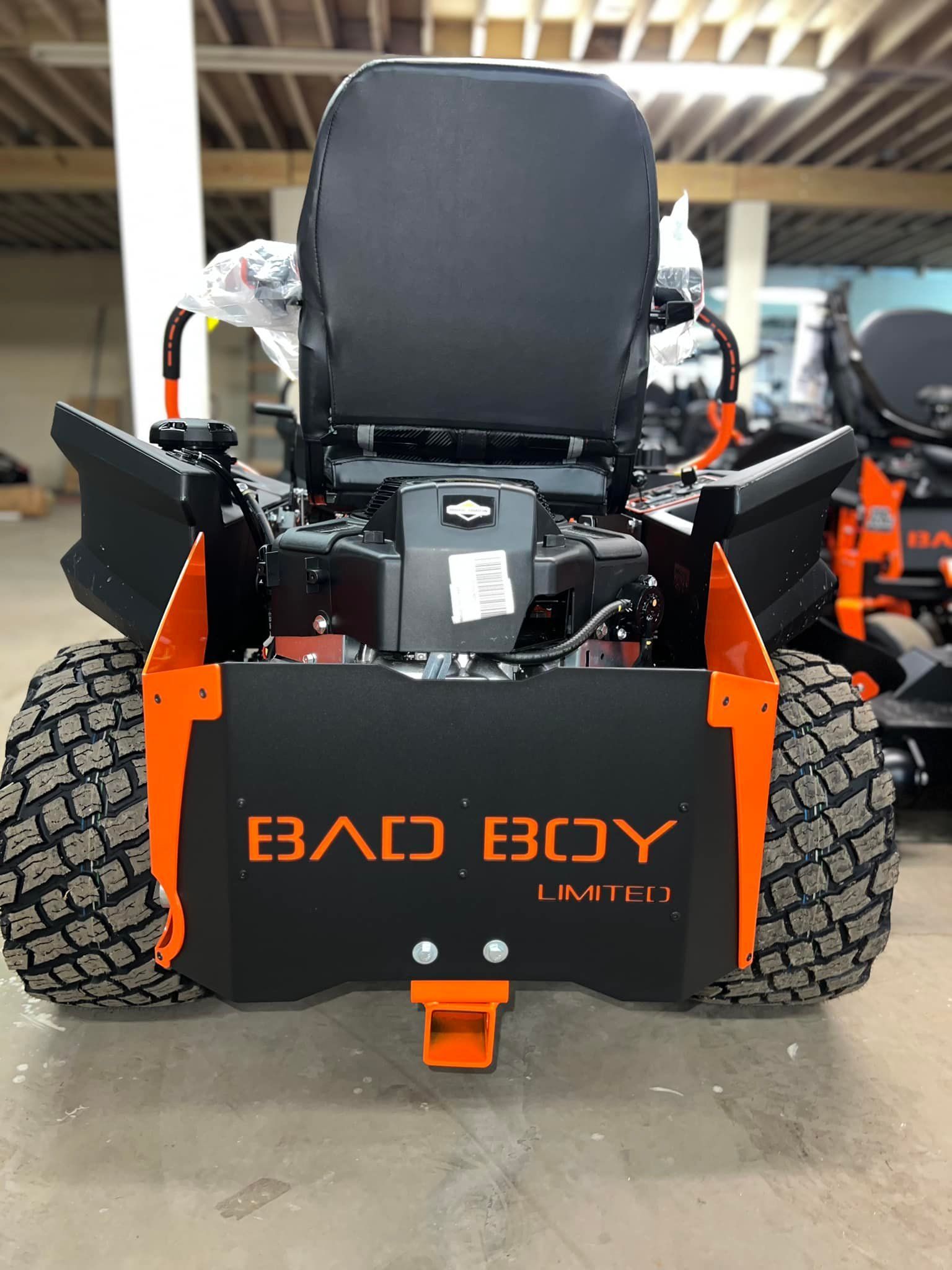 A bad boy lawn mower is parked in a garage