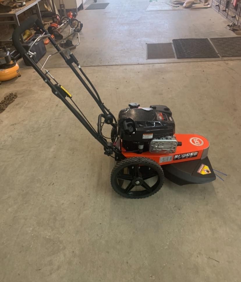A lawn mower is sitting on a concrete floor in a garage