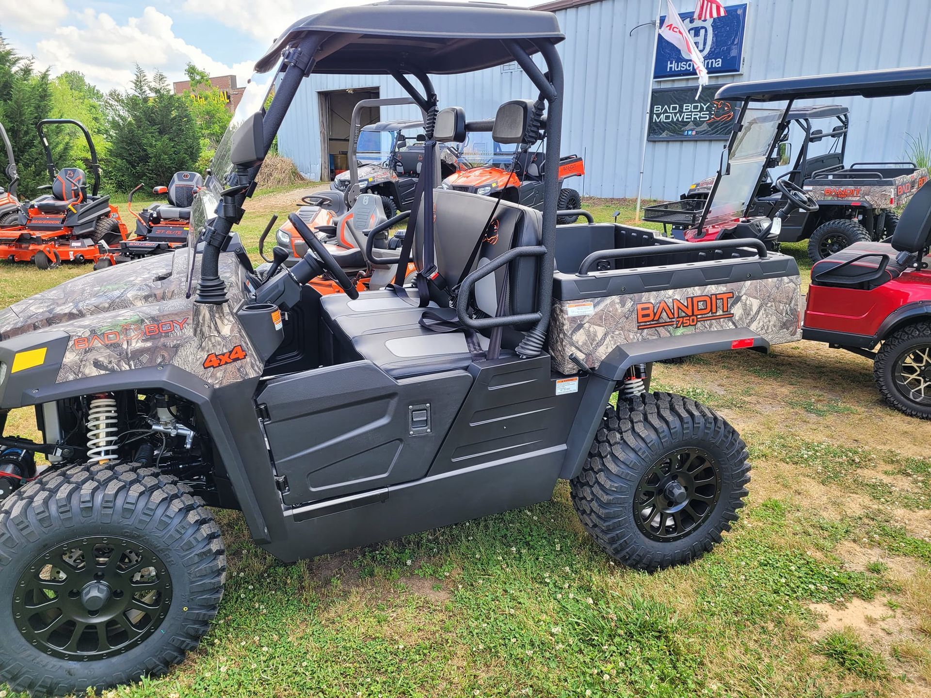 A utility vehicle is parked in a grassy field in front of a building.