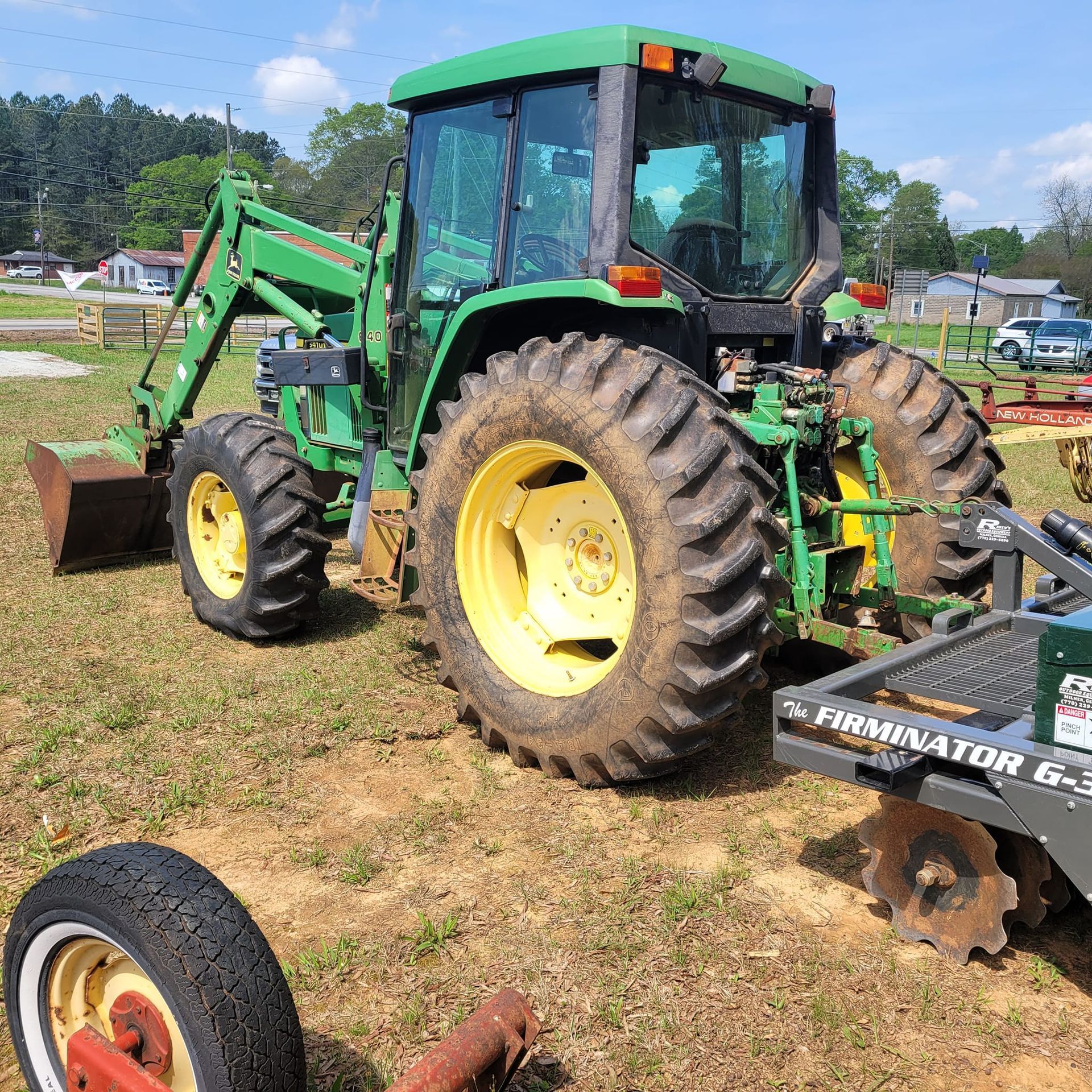 A green john deere tractor is parked in a grassy field.