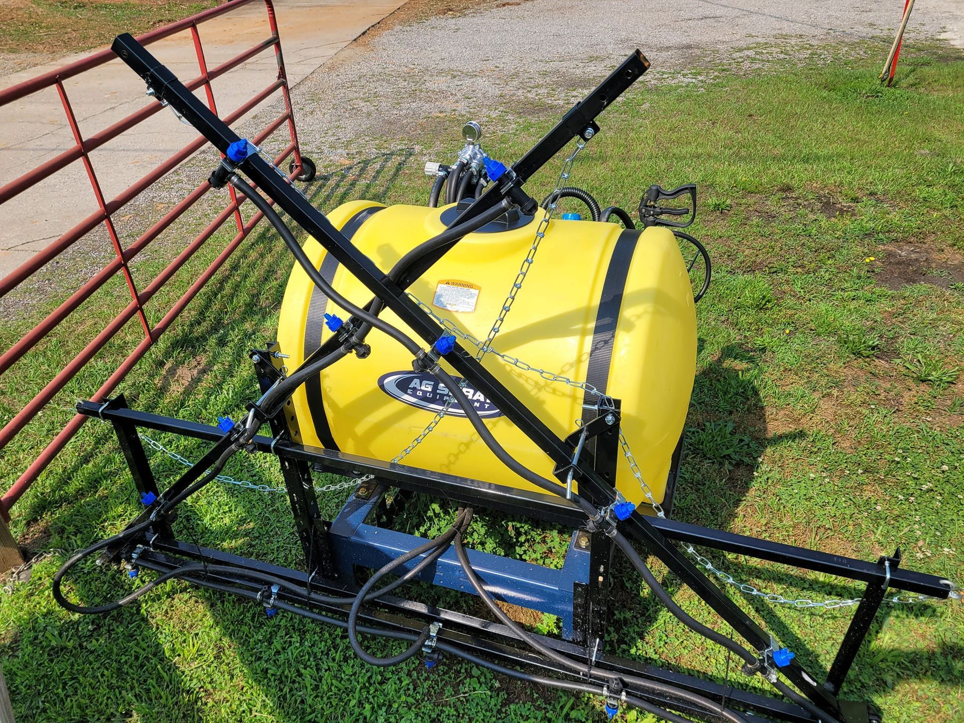 A yellow sprayer is sitting on top of a lush green field.
