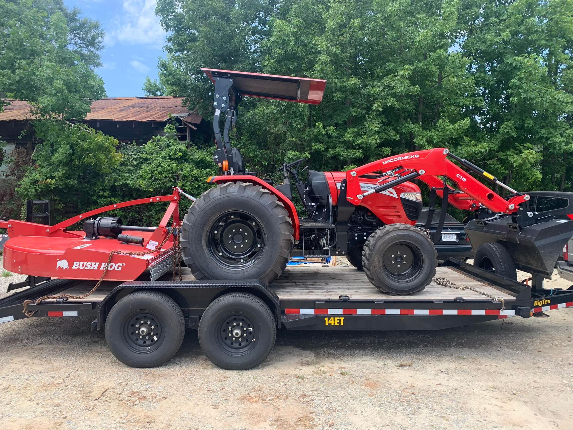 A red tractor is sitting on top of a trailer.
