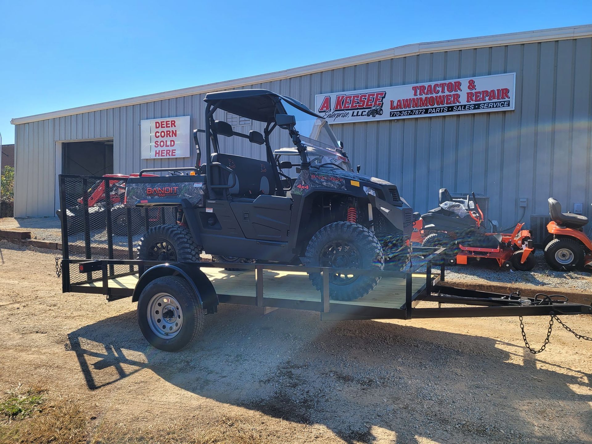 An atv is sitting on a trailer in front of a building.