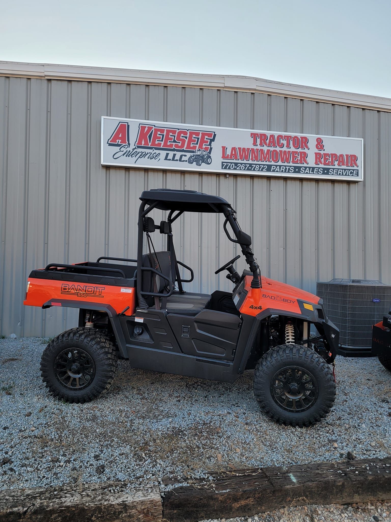 An orange atv is parked in front of a building.
