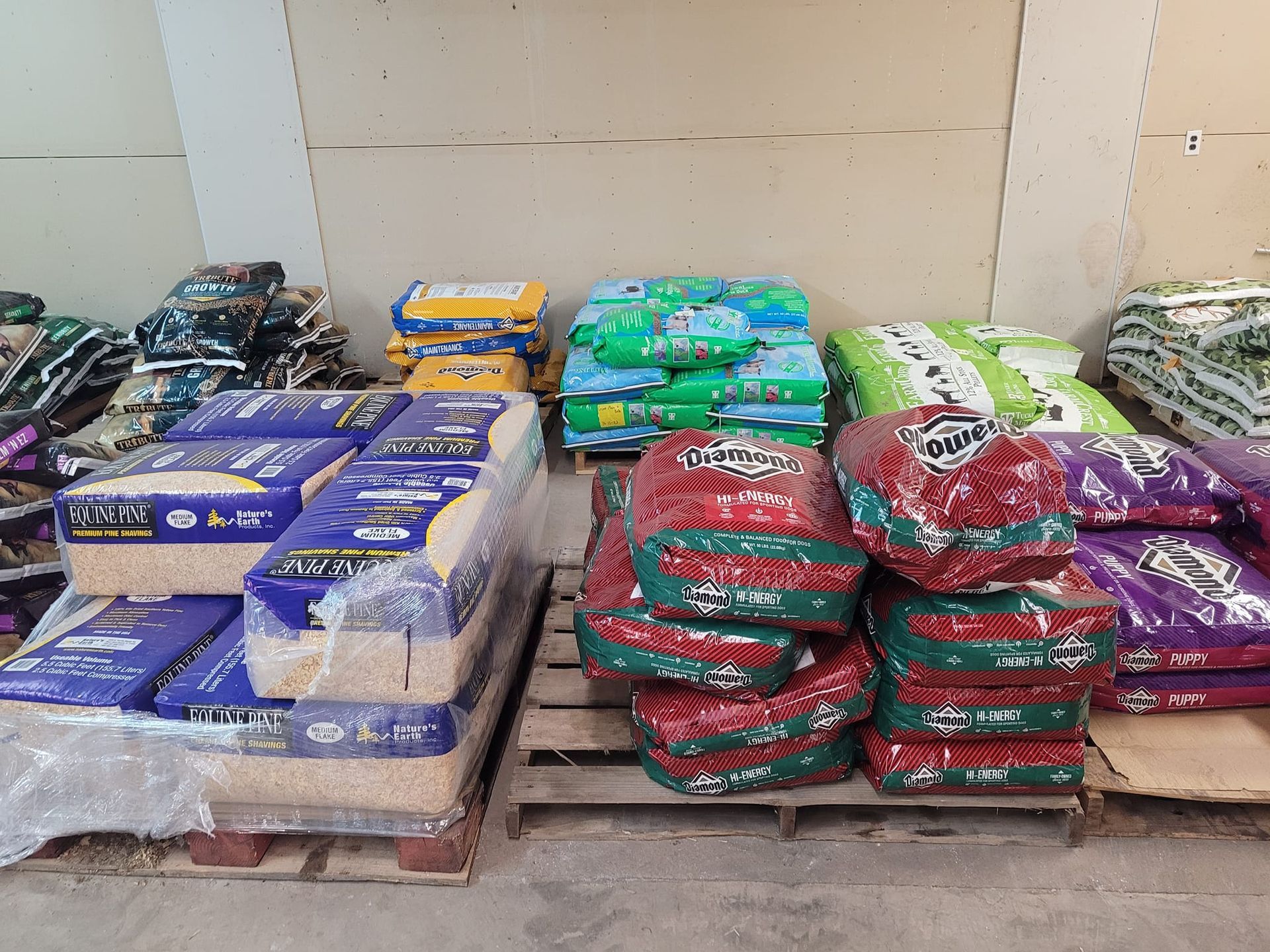 A bunch of bags of dog food are stacked on top of each other on pallets.