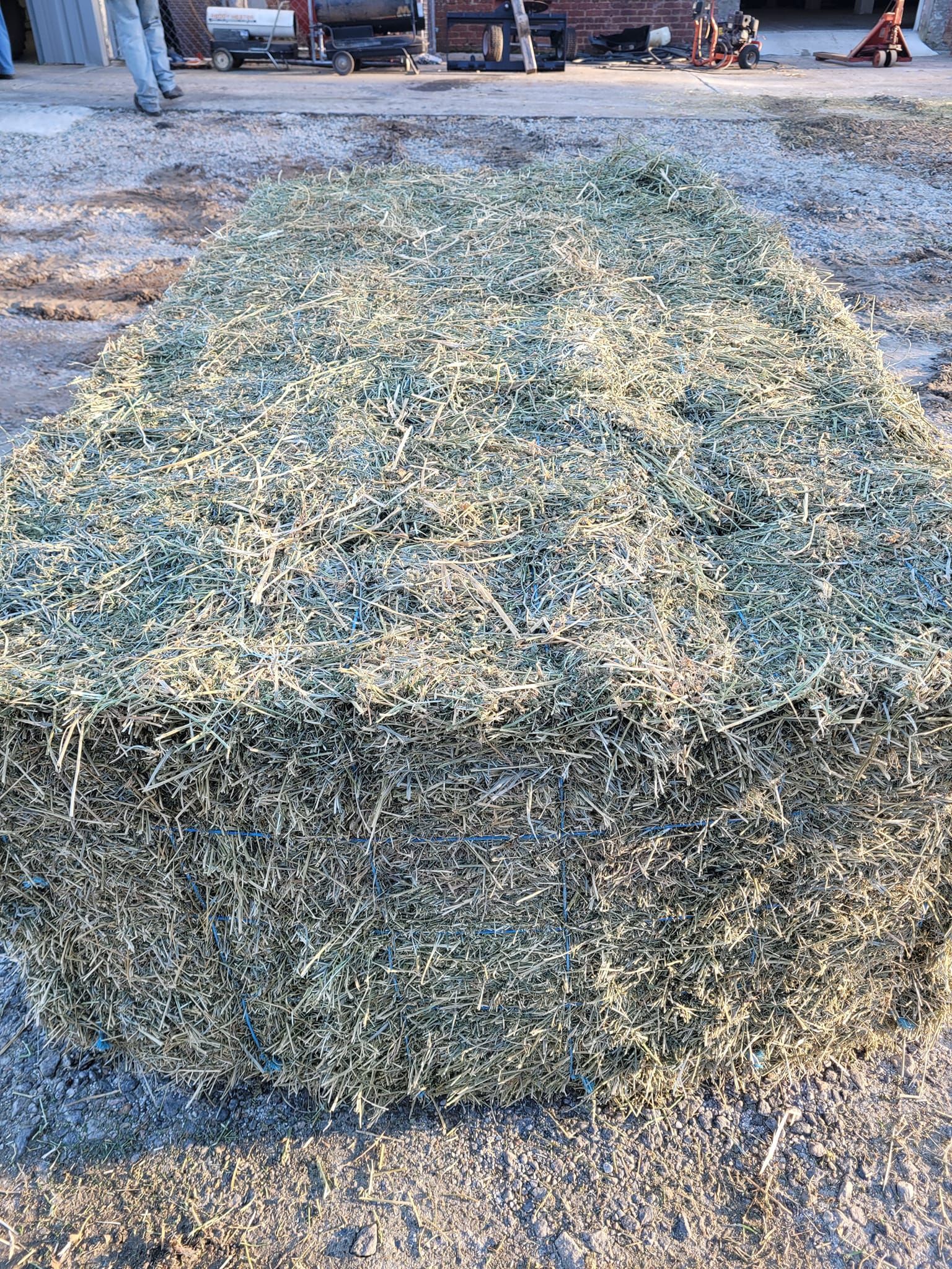 A large pile of hay is sitting on the ground.