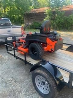 A lawn mower is sitting on top of a trailer.