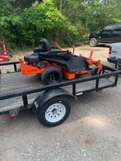 A lawn mower is sitting on top of a trailer.