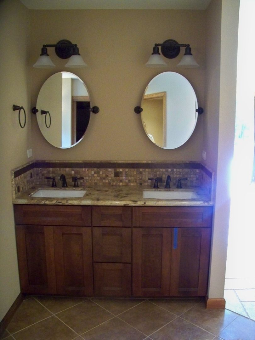 A bathroom with two sinks and two mirrors