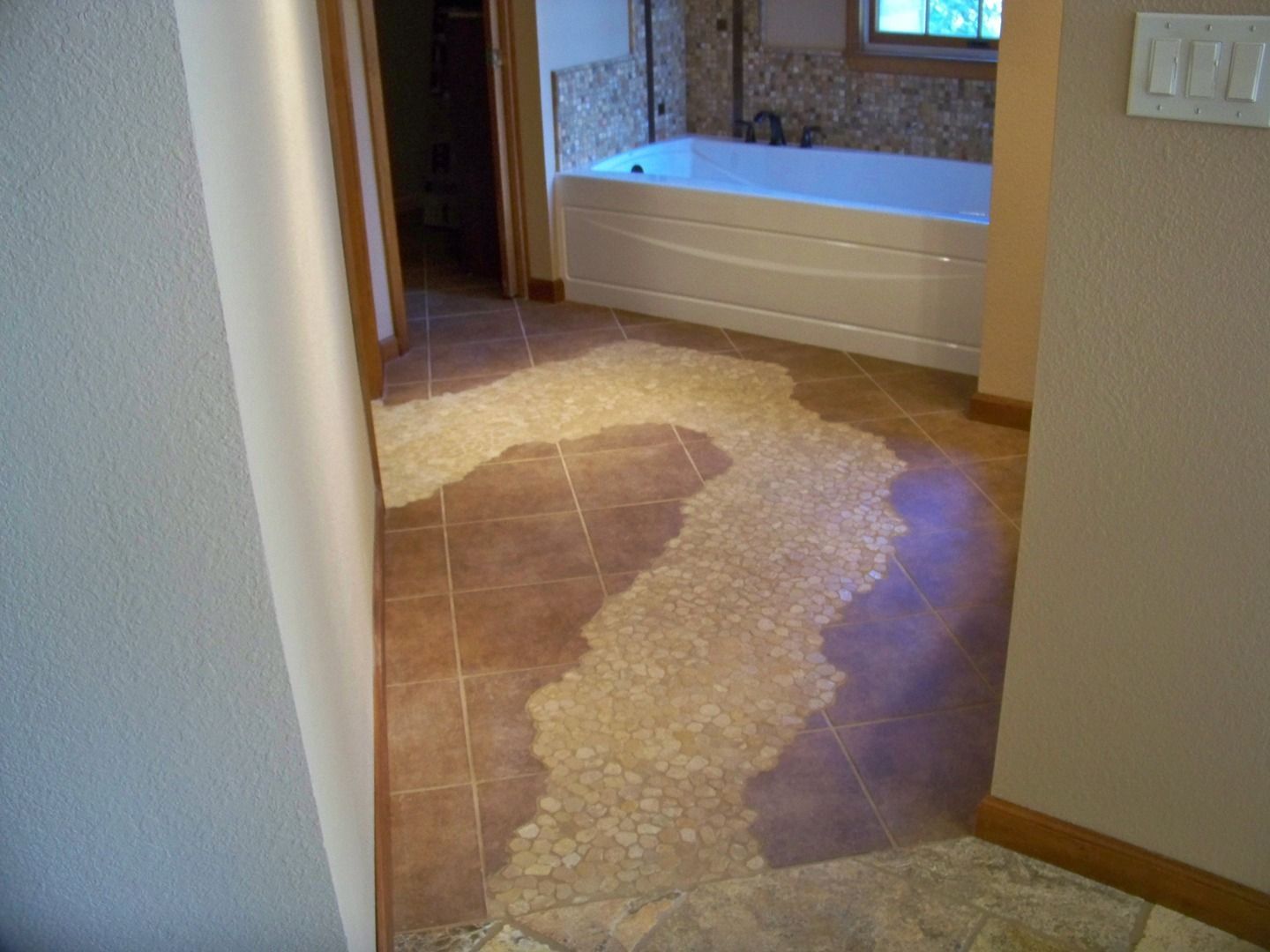 A bathroom with a bathtub and a tiled floor.