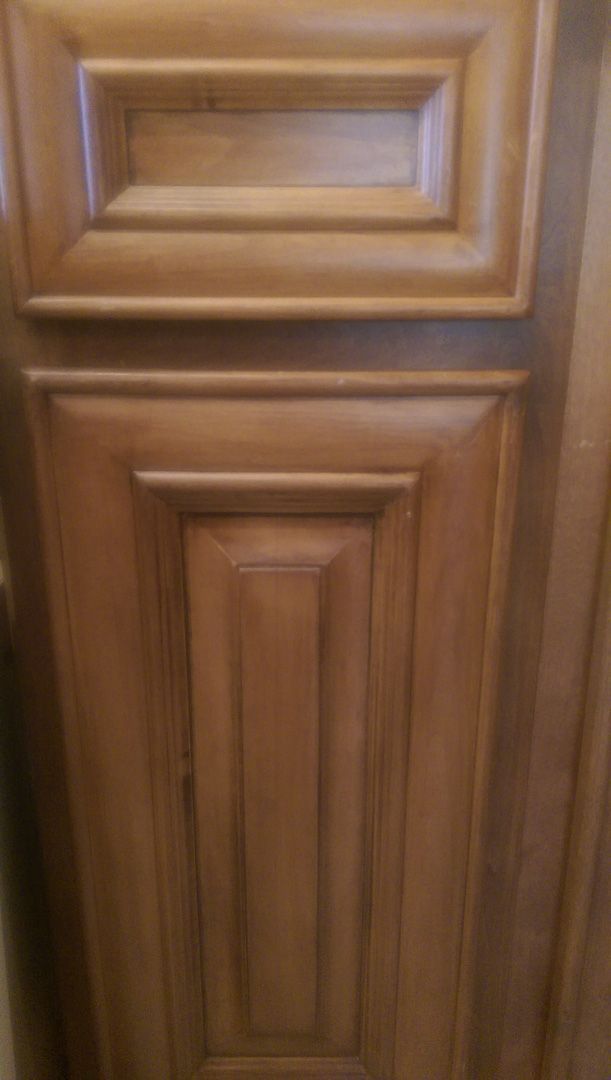 A close up of a wooden cabinet door in a kitchen.