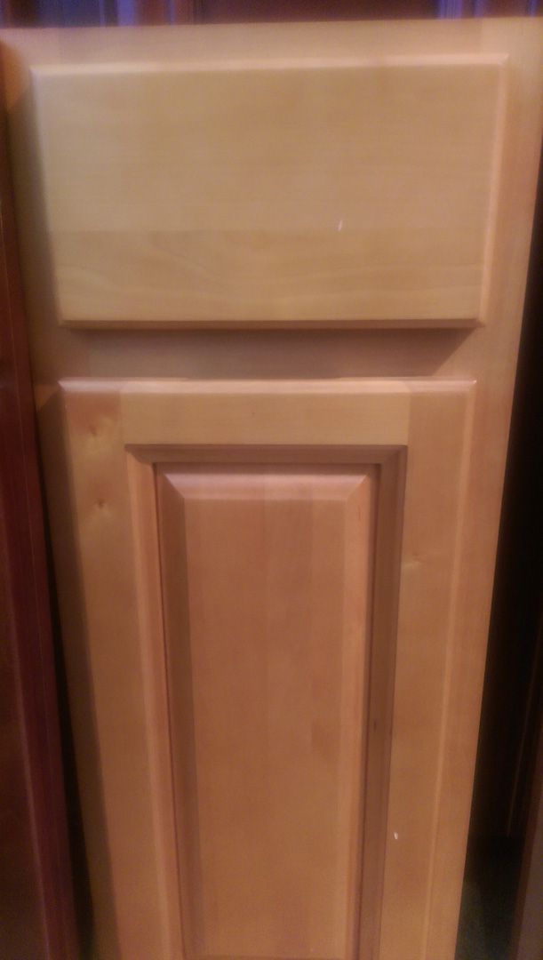 A close up of a wooden cabinet door in a kitchen.