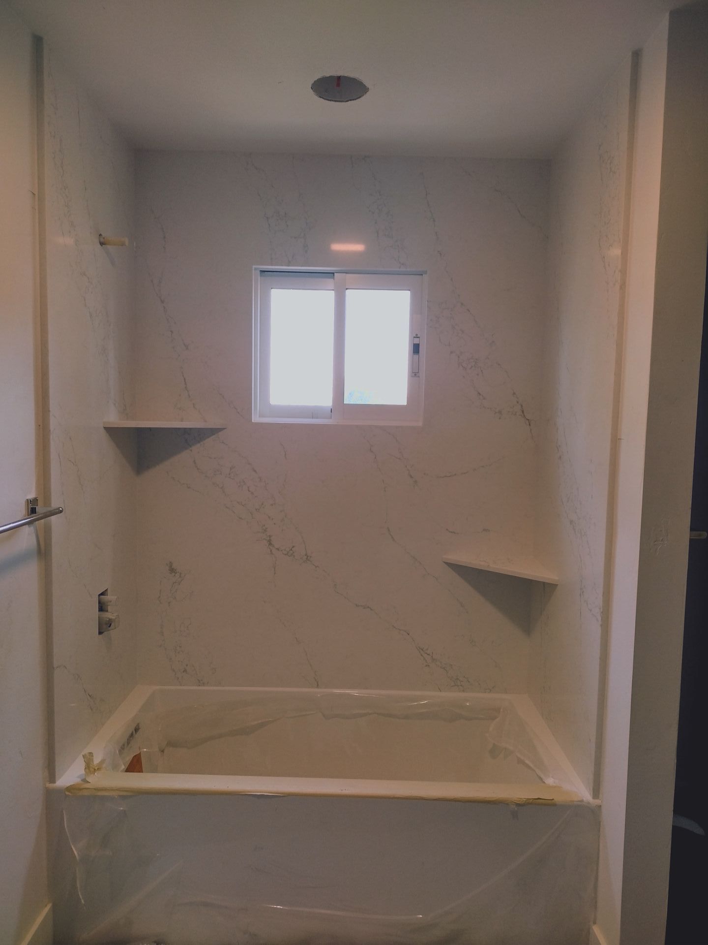A bathroom with a bathtub and a window.
