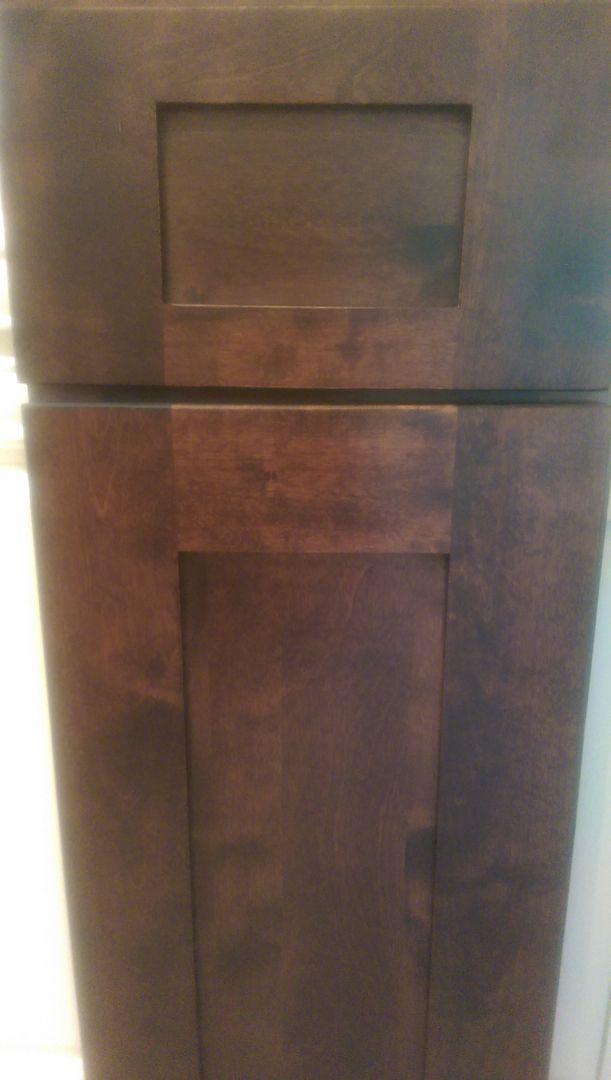 A close up of a wooden cabinet door in a kitchen.