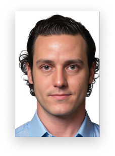 A man with curly hair and a blue shirt looks at the camera
