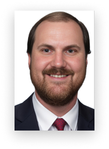 A man with a beard is wearing a suit and tie