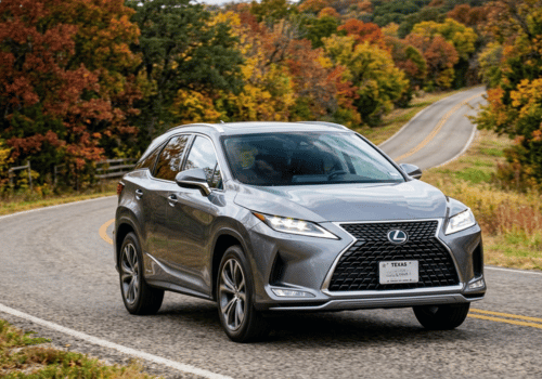 Gray Lexus RX driving along a winding road surrounded by colorful fall foliage