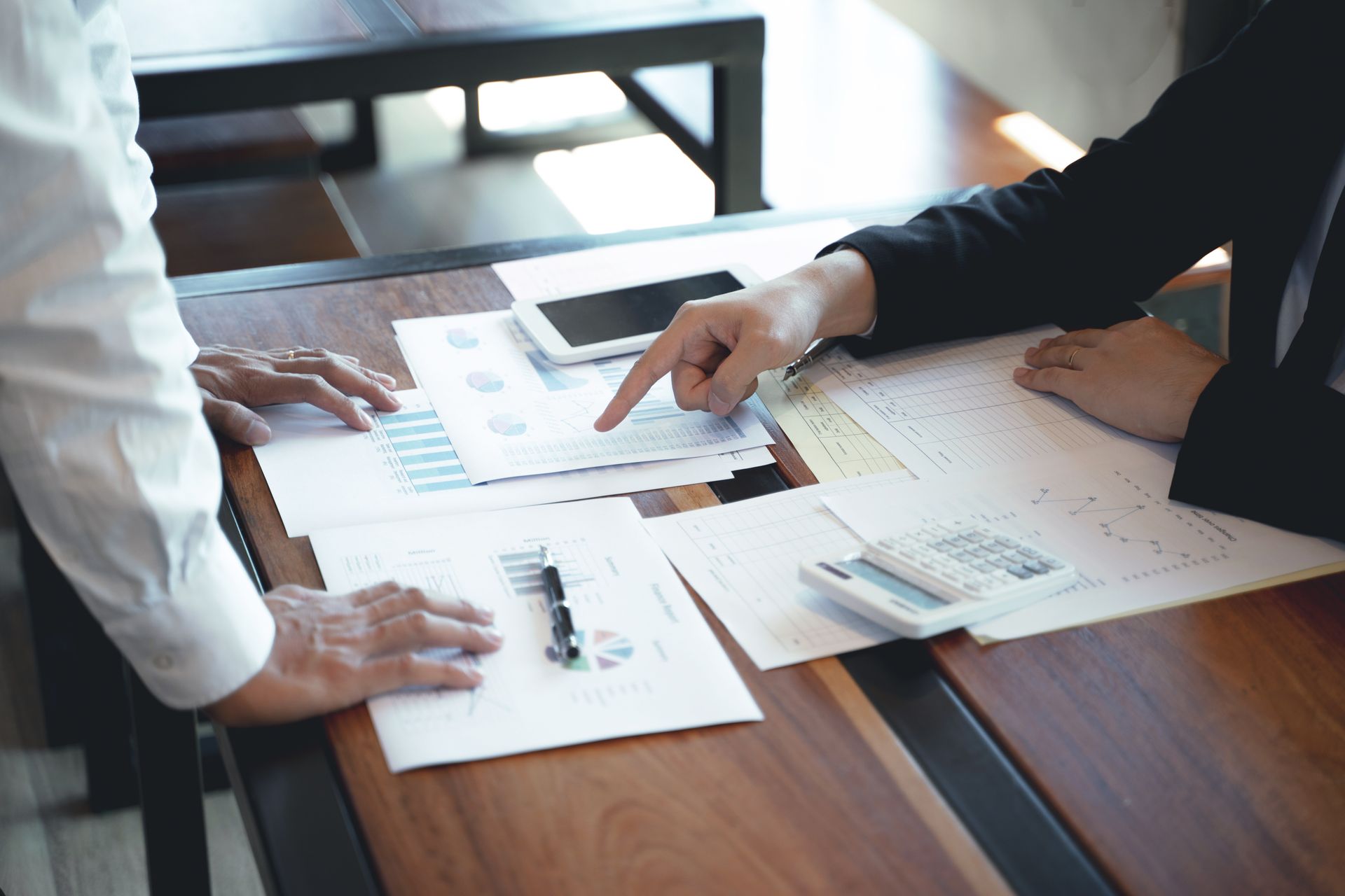 Two people review financial documents at a table