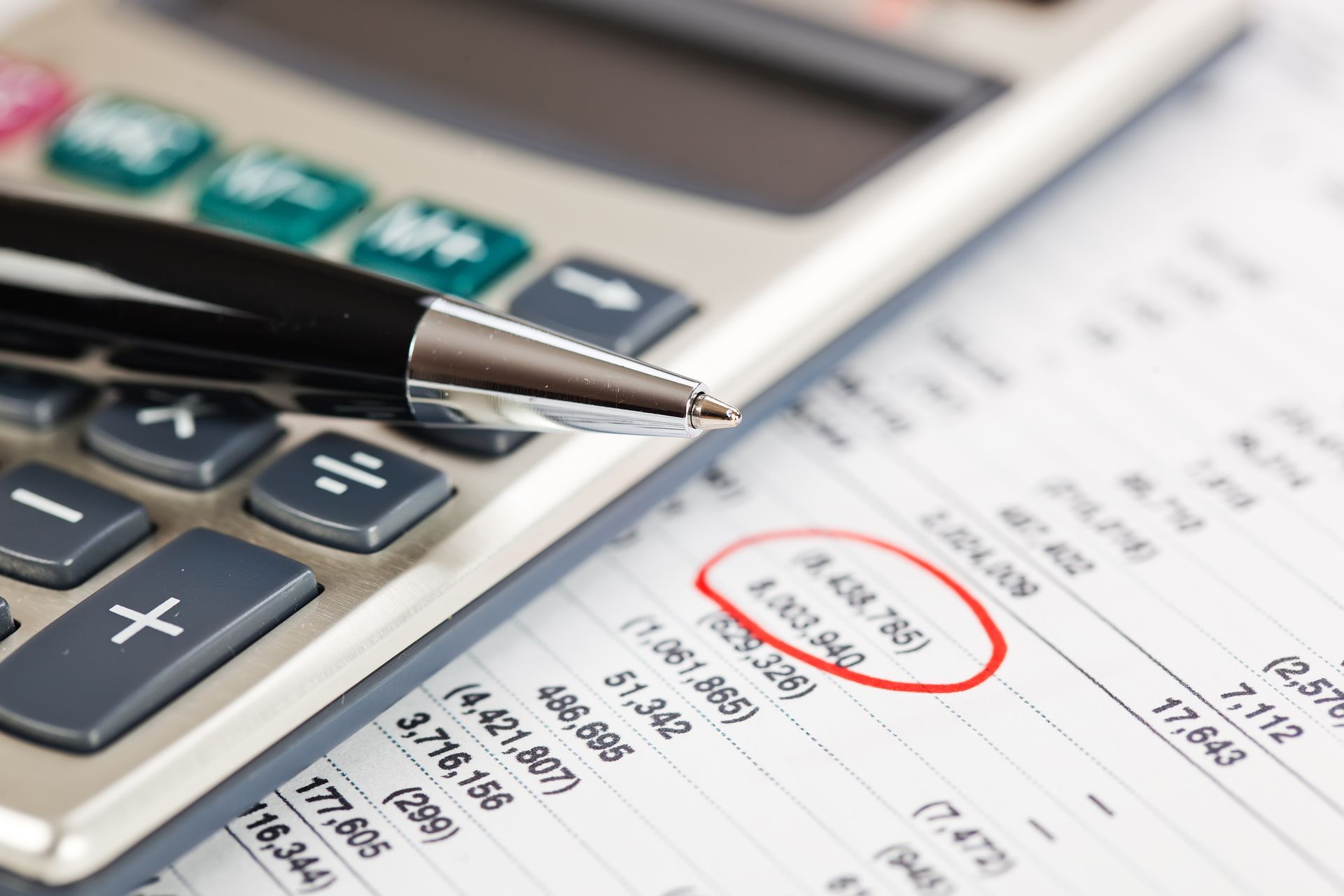 Calculator and pen resting on financial documents