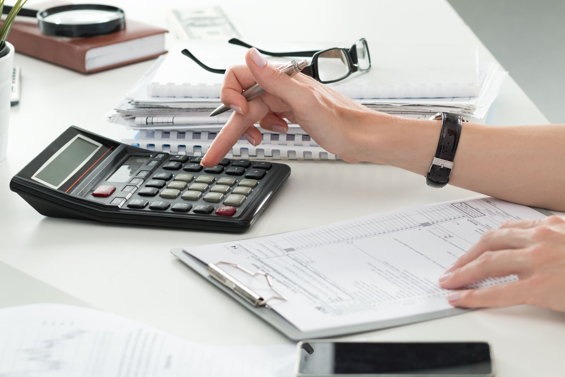 Person calculating taxes with a calculator