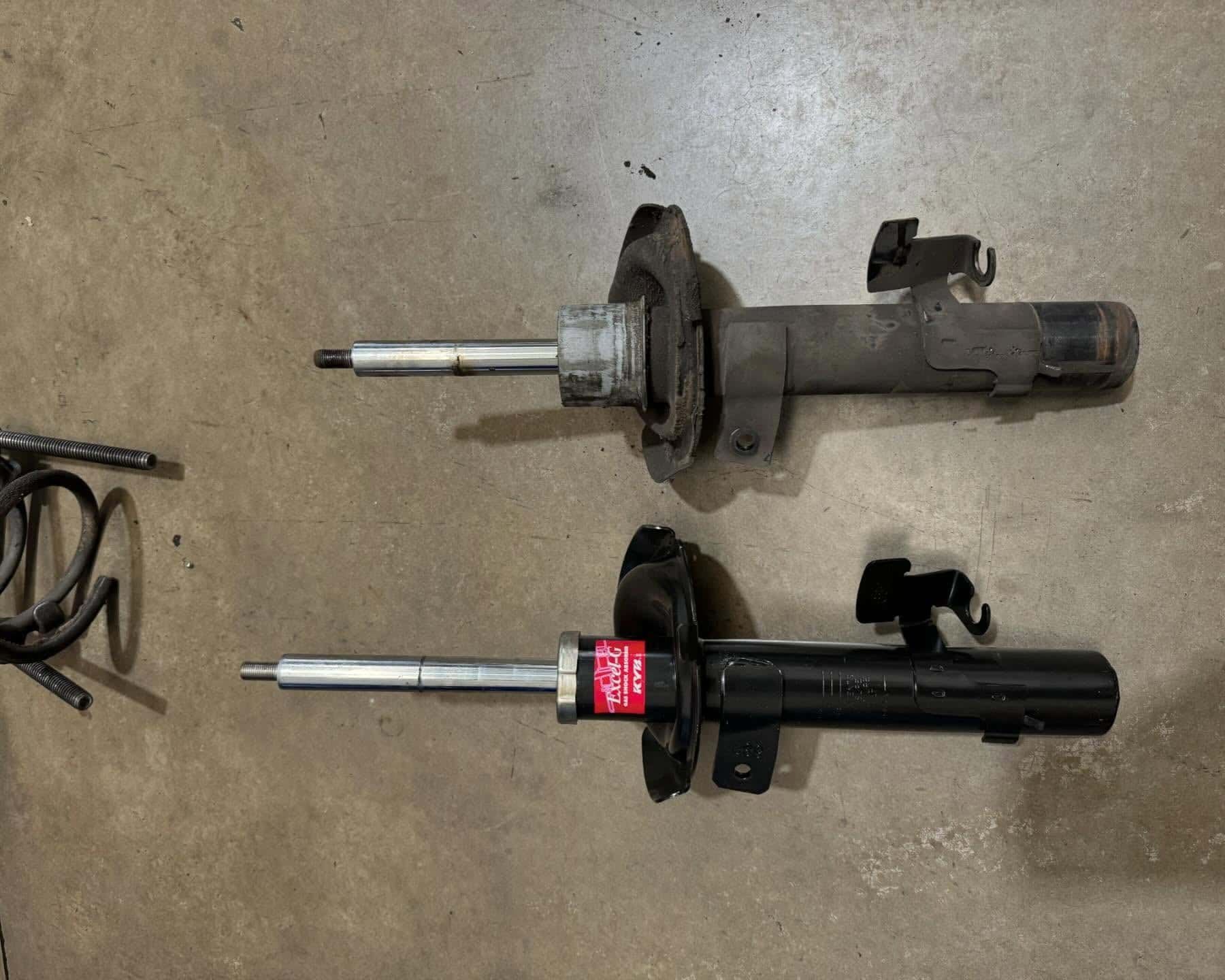 Two Shock Absorbers Are Sitting Next to Each Other on A Cement Floor — BEB Automotive In Shellharbour, NSW
