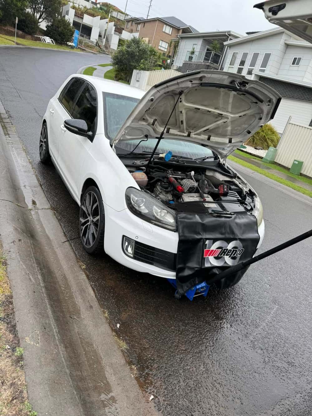 A White Car with The Hood Open Is Parked on The Side of The Road — BEB Automotive In Shellharbour, NSW
