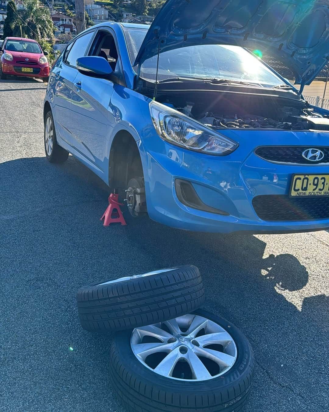 A Blue Car with The Hood up And A Tire on The Ground — BEB Automotive In Campbelltown, NSW
