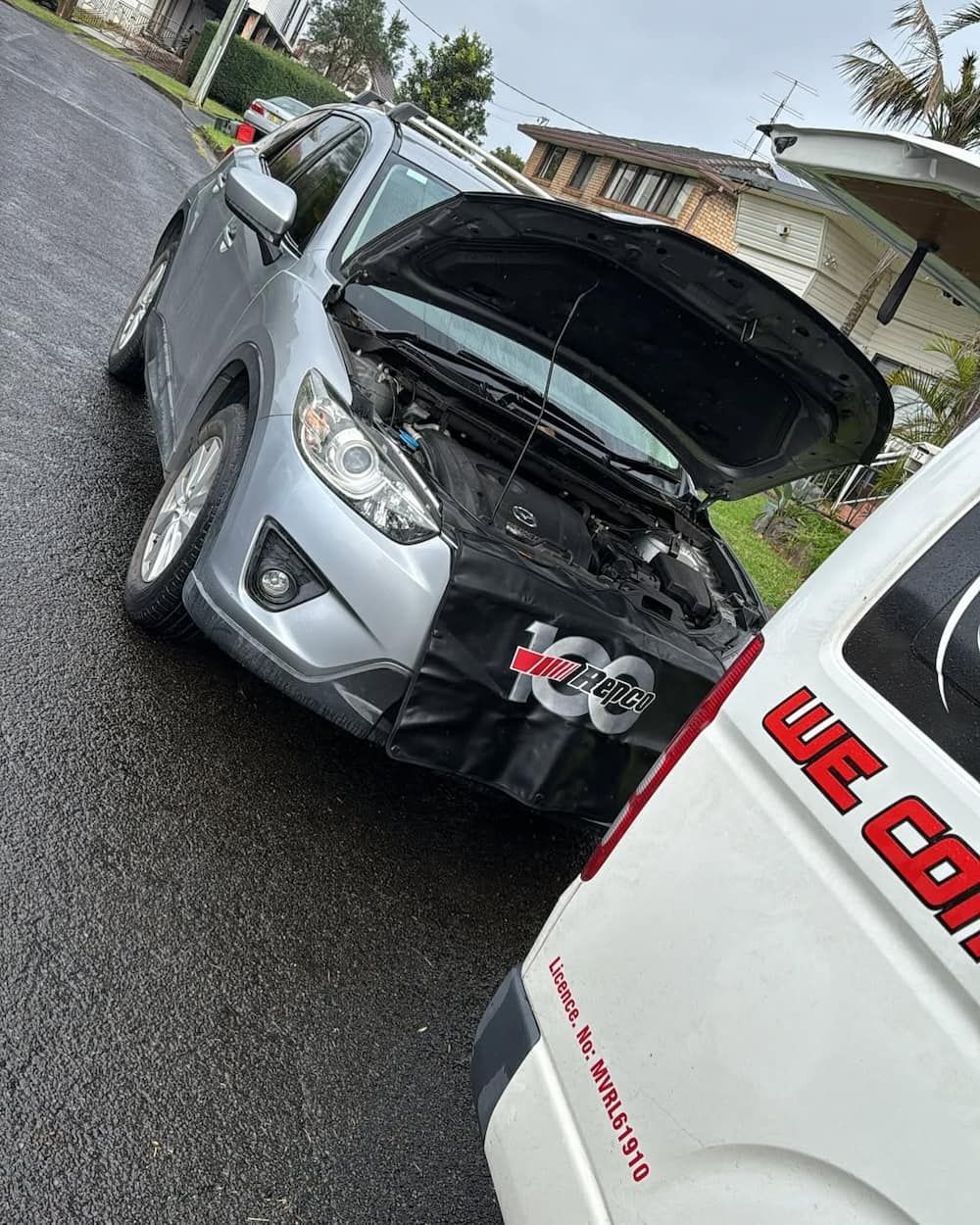 A Silver Car with Its Hood up Is Parked Next to A White Van — BEB Automotive In Narellan, NSW
