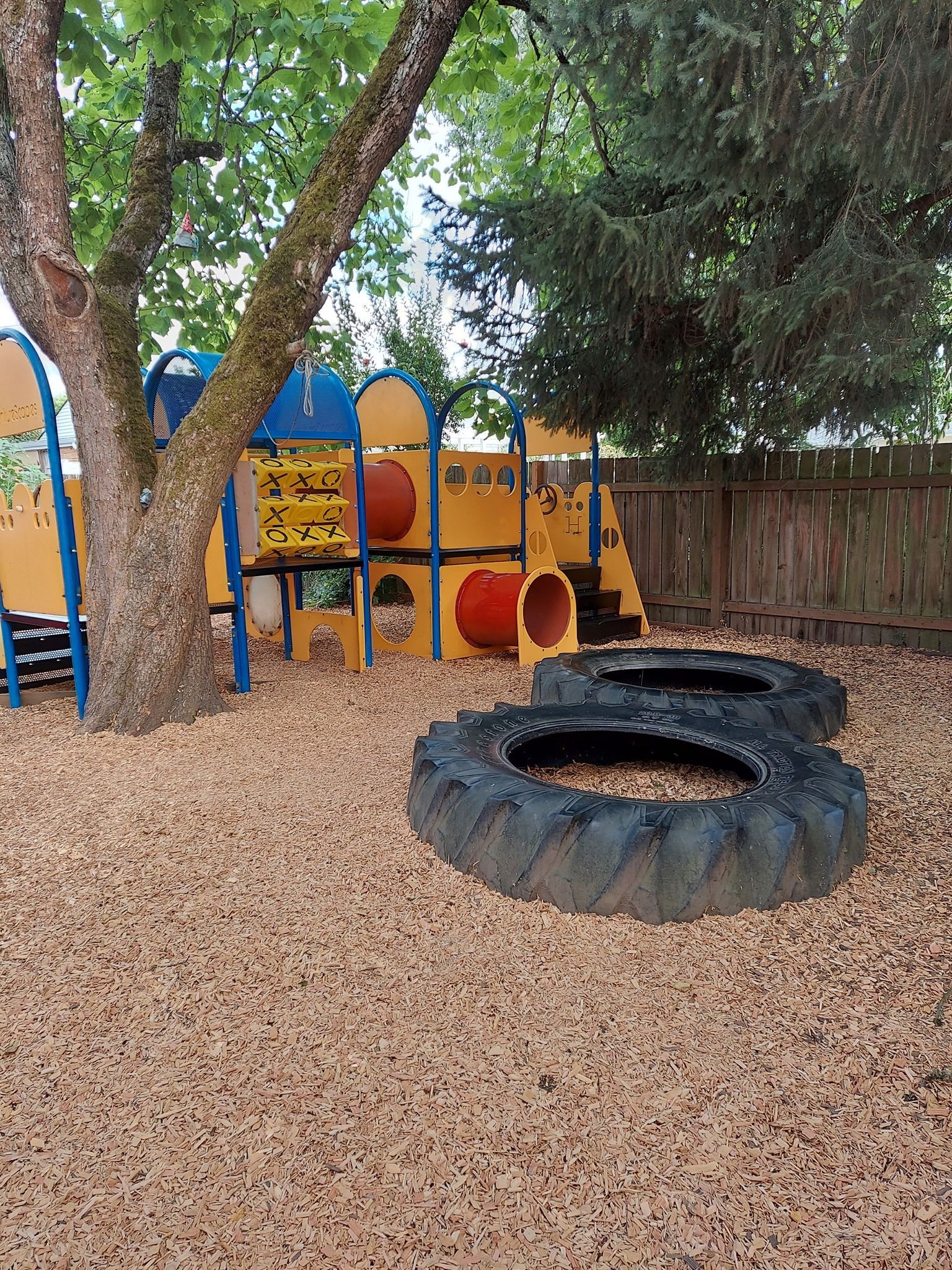 A playground with a tire in the middle of it.