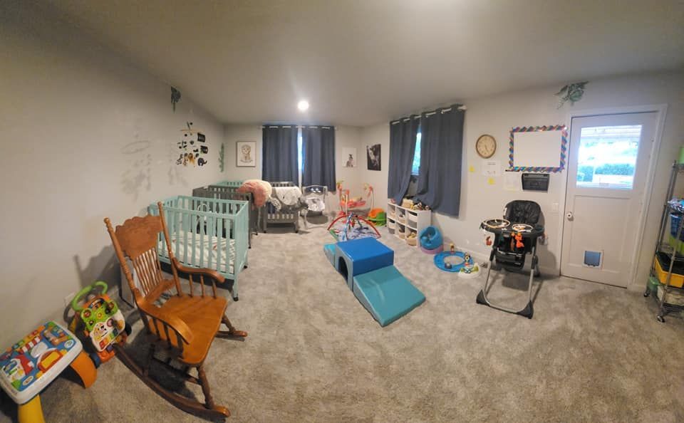 A large room filled with lots of toys and a rocking chair.