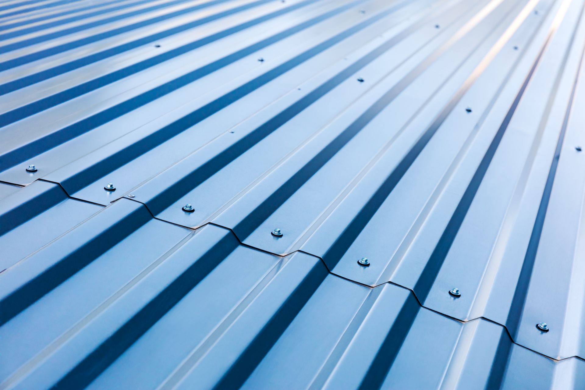 Blue corrugated metal roofing sheets stacked.