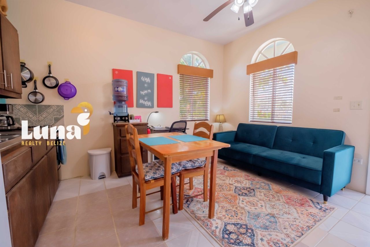 A living room with a table and chairs and a television