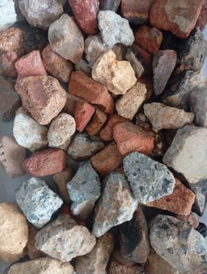 Pile of colorful rocks in shades of red, brown, tan, and gray.