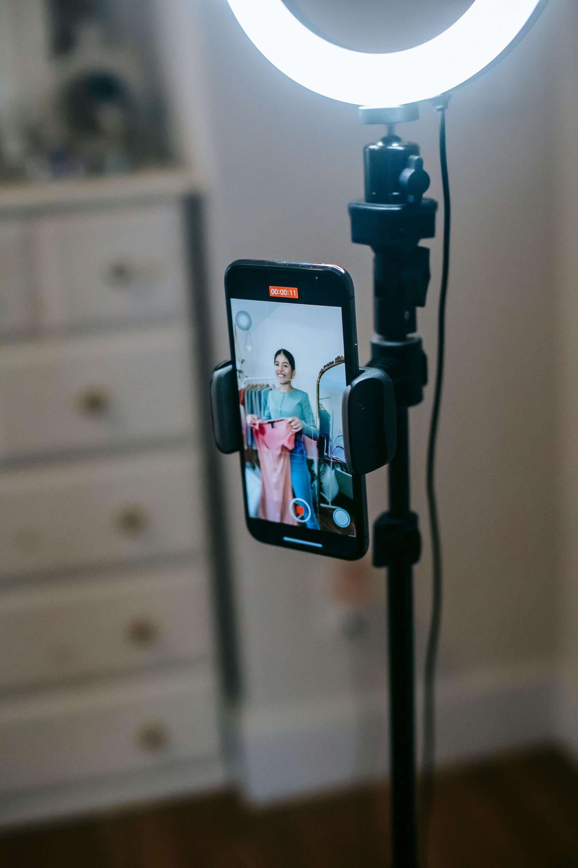 Ring light and smartphone on a tripod, showing a person posing in a room for Wilsona Marketing social media content services