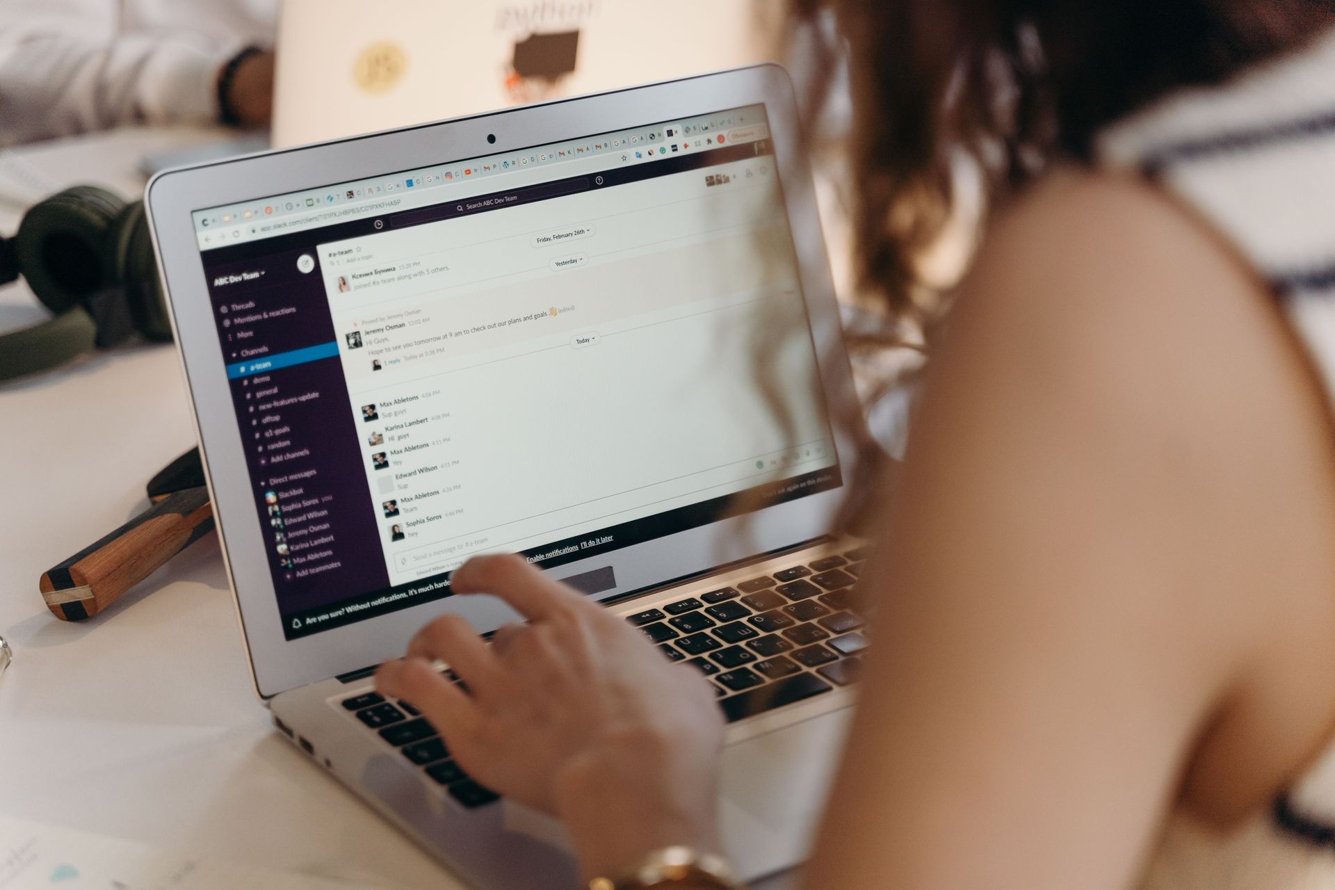 Person using a laptop at a desk, viewing a chat with a dark sidebar on screen representing CRM services by Wilsona Marketing