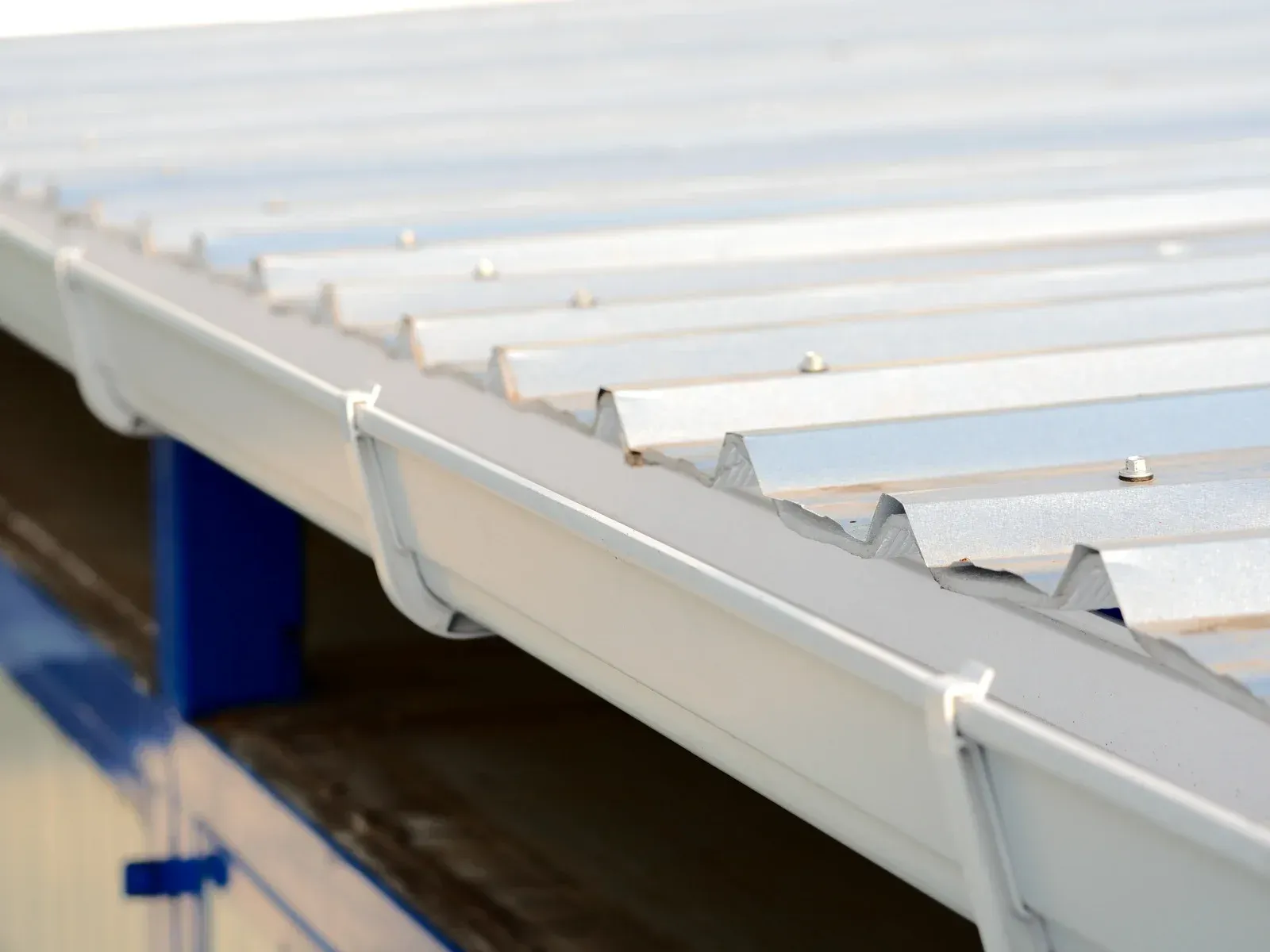 A close up of a white gutter on a metal roof