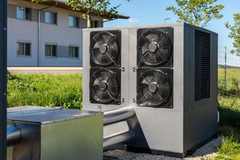 Outdoor HVAC unit with four fans beside a building on a sunny day Outdoor HVAC unit with four fans beside a building on a sunny day