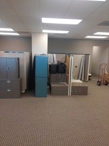 A large empty room with a lot of furniture and boxes on the floor.