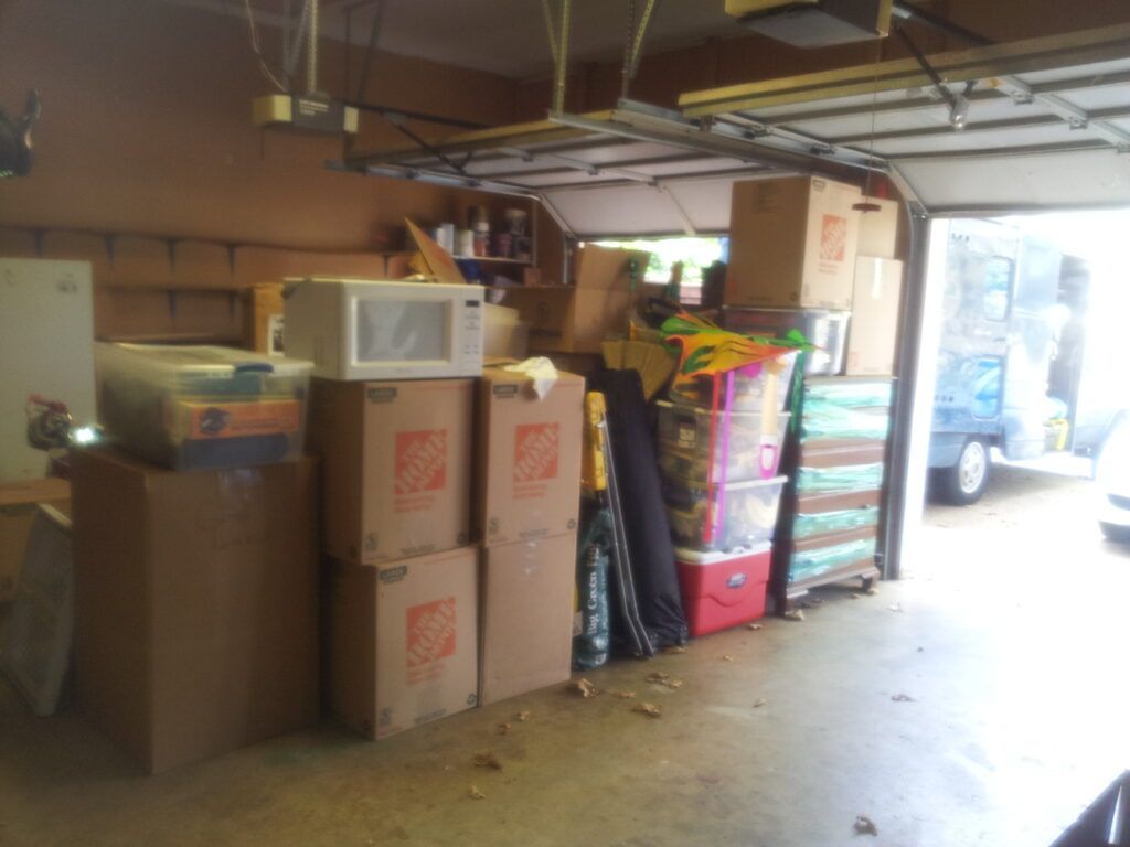 A garage filled with lots of boxes and a microwave