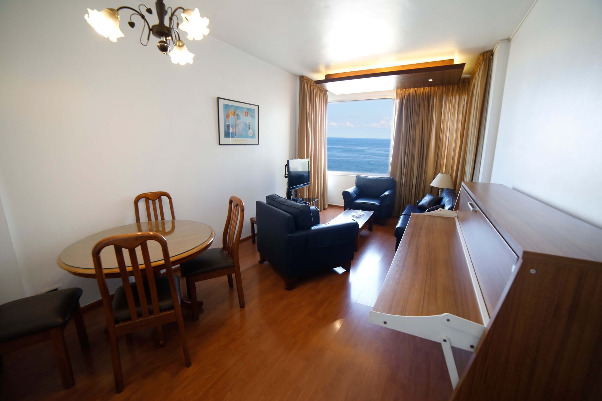 A living room with a table and chairs and a picture on the wall