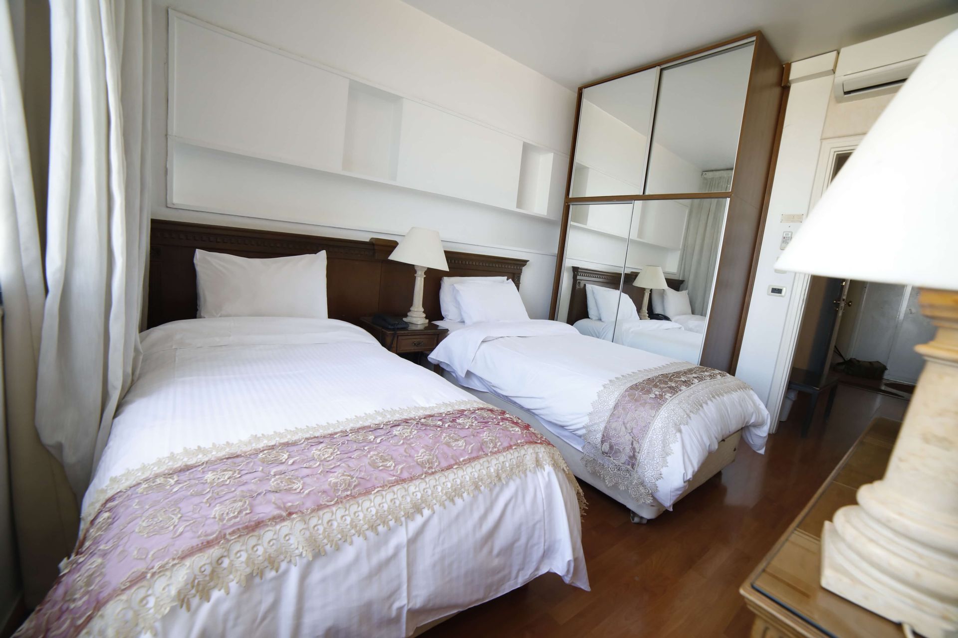 A hotel room with two beds and a lamp
