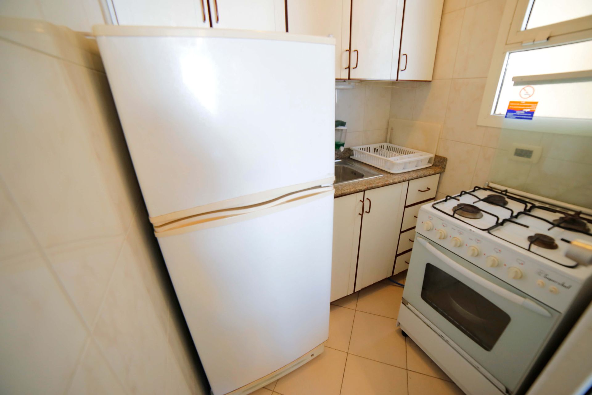 A kitchen with a white refrigerator and stove