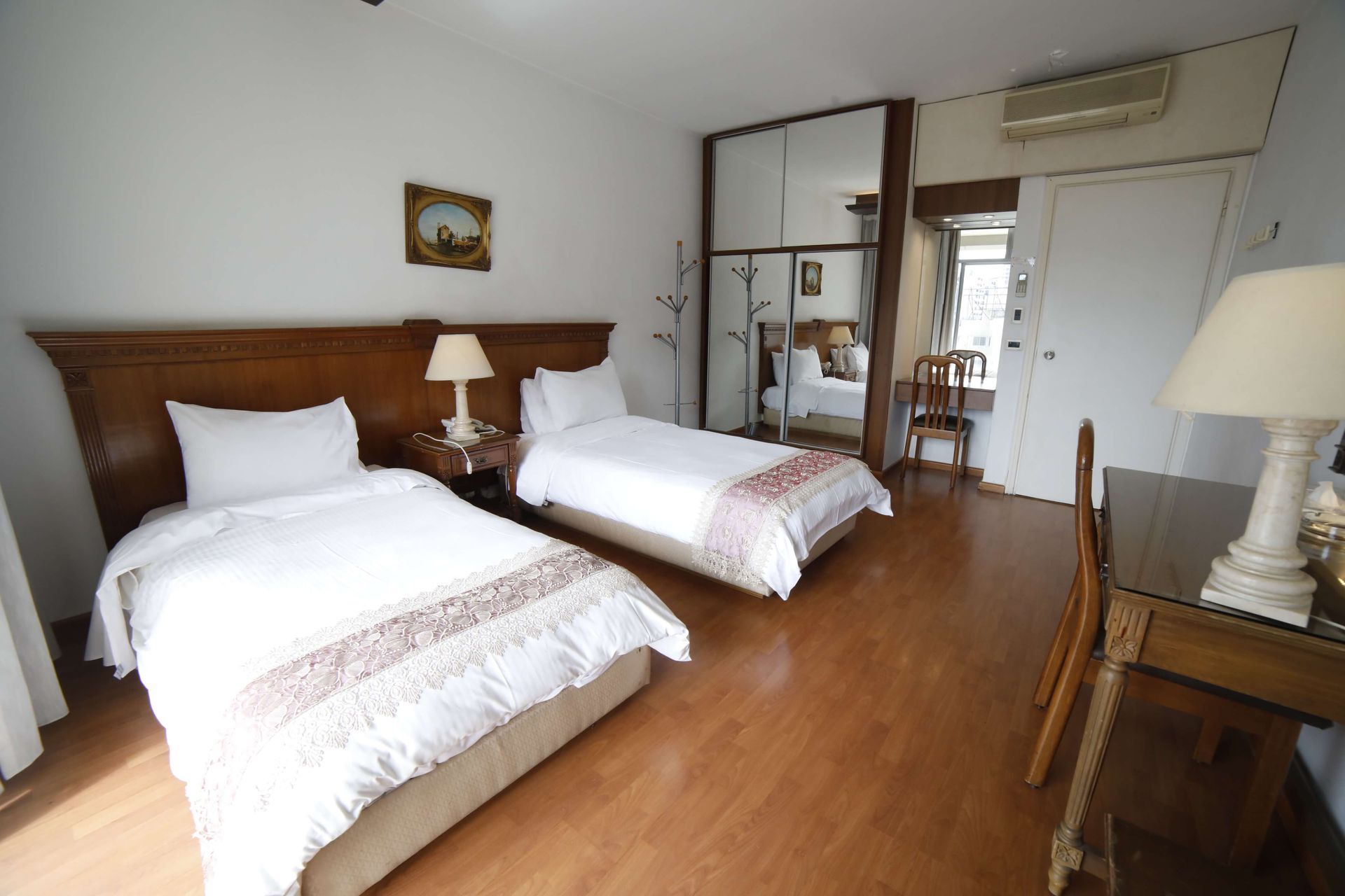 A hotel room with two beds and a desk