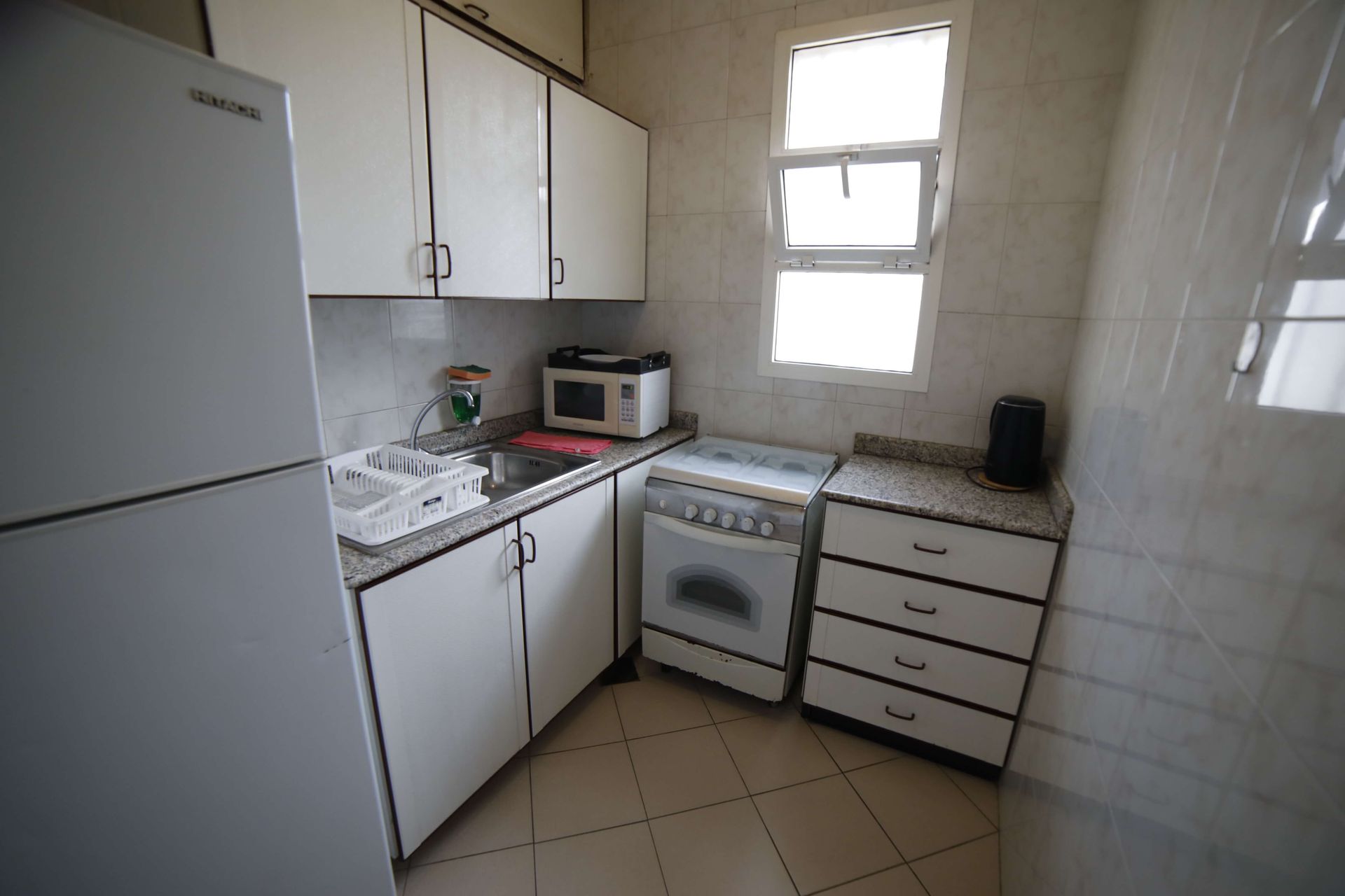A kitchen with white cabinets and a samsung refrigerator