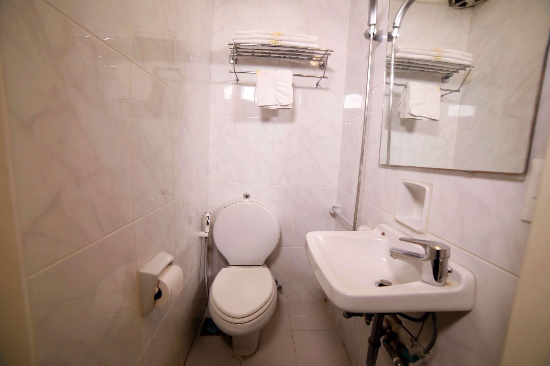 A bathroom with a toilet a sink and a mirror