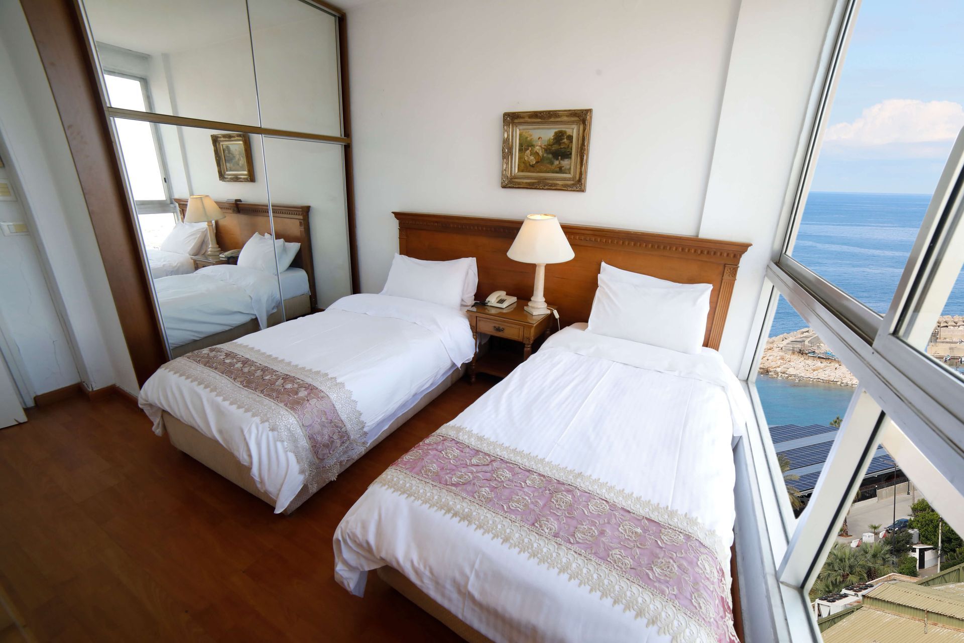 A hotel room with two beds and a large window overlooking the ocean