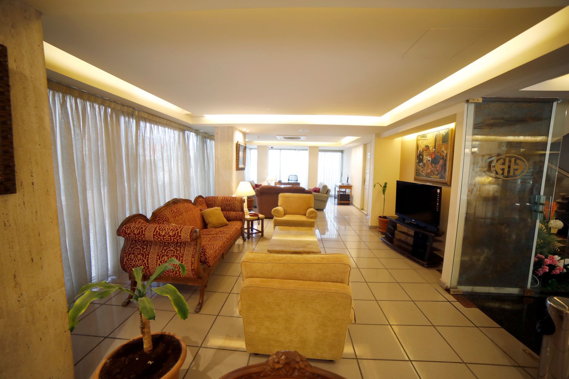 A living room with a couch and chairs and a tv