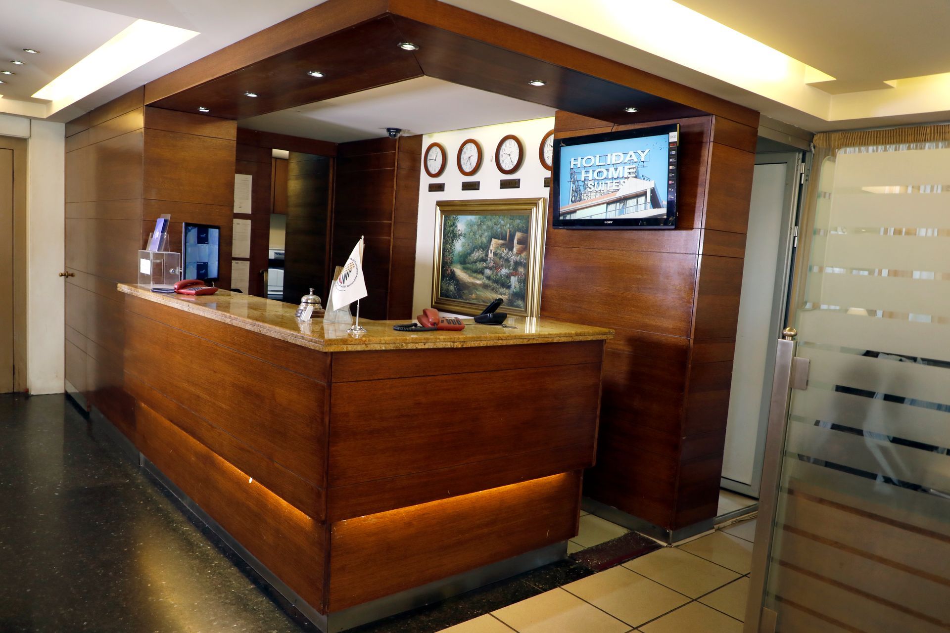A hotel lobby with a wooden counter and a television