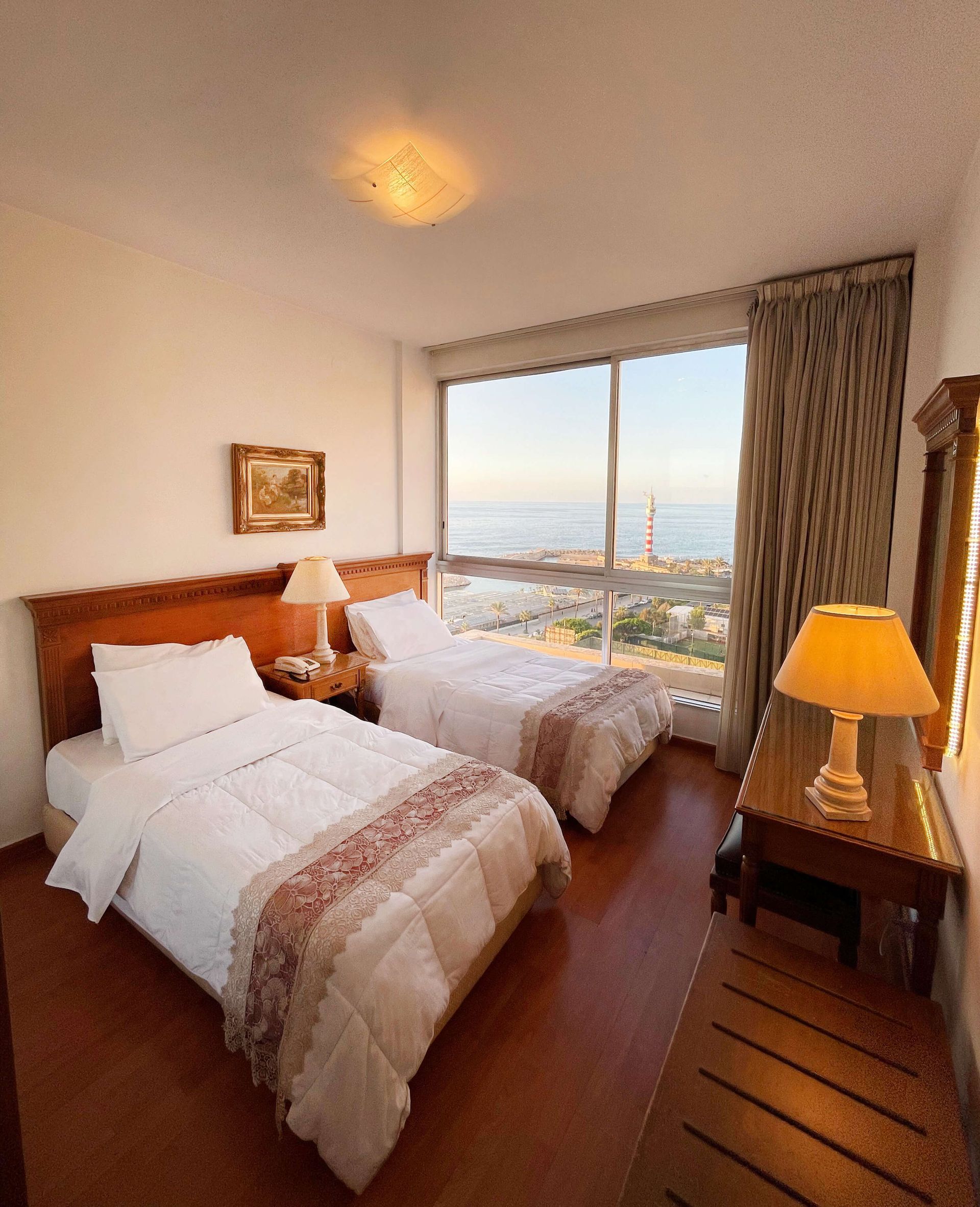 A hotel room with two beds and two lamps